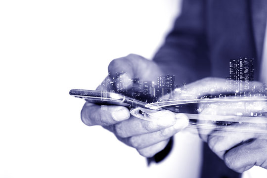 Double exposure of businessman using smartphone and city - Powered by Adobe