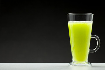 green smoothie on black background with blank space for text
