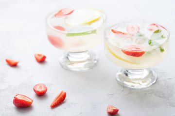 Citrus linfused emonade water with lemon sliced , healthy and detox water drink in summer on concrete table.