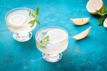 Citrus linfused emonade water with lemon sliced , healthy and detox water drink in summer on blue.