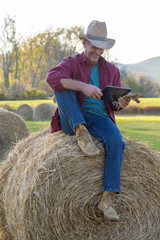 Smiling Happy ranch Worker Using Mobile Tablet