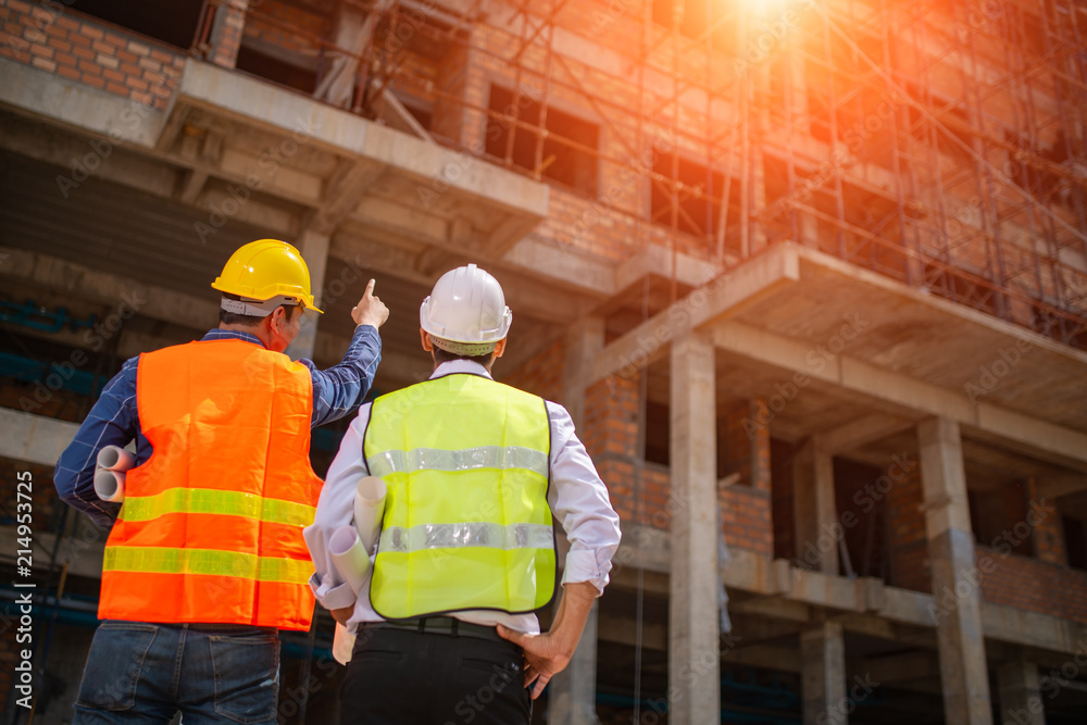 Wall mural construction engineers discussion with architects at construction site or building site of highrise 