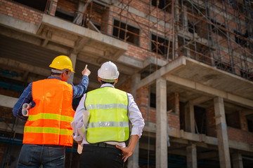 Construction engineers discussion with architects at construction site or building site of highrise...