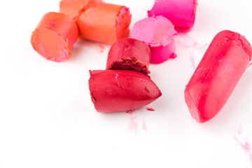Close up of multi-colored lipstick slices on white