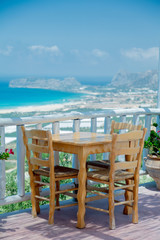 Wooden table in cafe with mountains and sea on background, Falassarna region, Crete, Greece