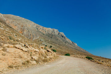 Fototapeta na wymiar Idylic west Crete landscape with goats countryside road in summertime season, Greece