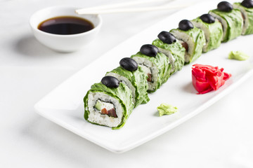 Vegetarian sushi rolls in lettuce leaves on white background