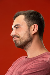 Fototapeta premium Beautiful bored man bored isolated on red background
