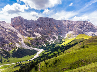 Italian Dolomites Landscape. Light after rain in Dolomites. Rocky peaks in the background surrounded by rain clouds. Mountain valley with layers of forest and mountains. Beautiful light in Alps. Italy