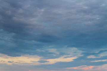 Summer sunset in the cloudy sky above the sea
