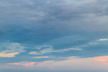 Summer sunset in the cloudy sky above the sea