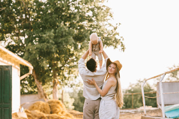back view of woman standing near husband with son on hands at countryside