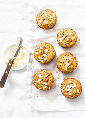 Oatmeal mini muffins with apricots, apples, carrots and nuts on light background, top view. Copy...