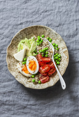 Bowl with quinoa, egg, avocado, tomato, green pea. Healthy diet food concept. Top view, copy  space