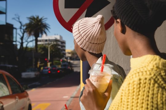 Twins siblings waiting for bus at bus stop
