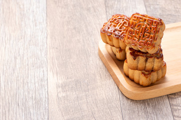 Mooncake in chinese traditional mid-autumn festival(moon festival) on wooden table background with copy space(text space) and table setting, close up.