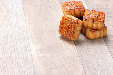 Fototapeta premium Mooncake in chinese traditional mid-autumn festival(moon festival) on wooden table background with copy space(text space) and table setting, close up.