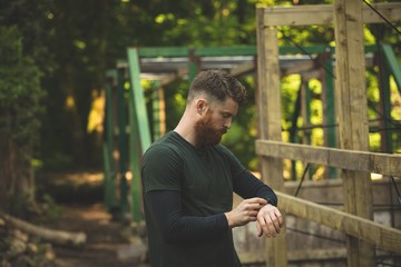Fit man using smartwatch at boot camp