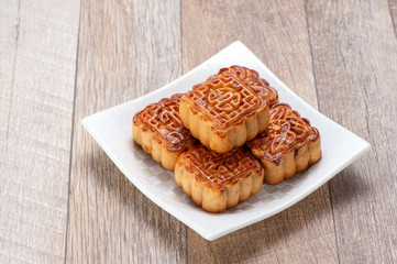 Mooncake in chinese traditional mid-autumn festival(moon festival) on wooden table background with copy space(text space) and table setting, close up.