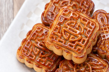 Mooncake in chinese traditional mid-autumn festival(moon festival) on wooden table background with copy space(text space) and table setting, close up.