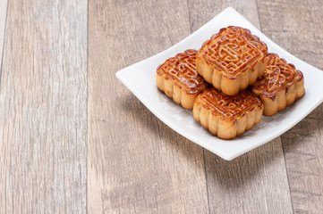 Mooncake in chinese traditional mid-autumn festival(moon festival) on wooden table background with copy space(text space) and table setting, close up.