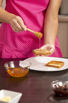 Woman making honey and butter sandwich
