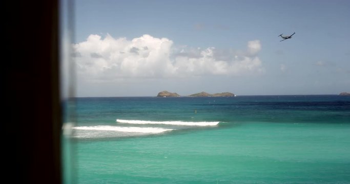 Vue sur la mer depuis une fen&ecirc;tre, un avion d&eacute;colle - Saint Barthelemy