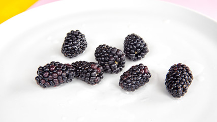 closeup of blackberries on white plate