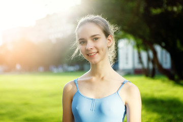 Portrait of ballet dancer dancing outdoor. Young ballerina in blue sportwear. Portrait of young lovely pretty beautiful girl in the park.