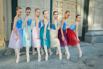 Ballet dancers dancing on street. Young ballerinas in color tutus. Ballet feet on the point