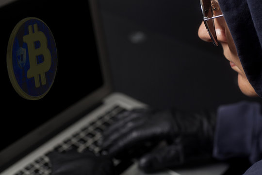 Crypto Hacker with laptop and bitcoin .Concept of internet criminal hacking