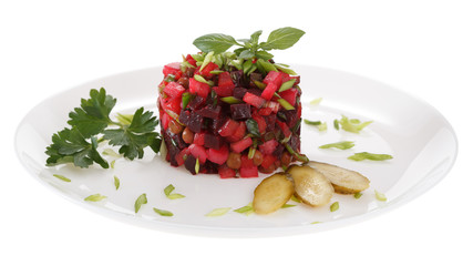 Vinaigrette salad is served on a  plate, decorated with fresh Basil, pickles and green parsley. Isolated on white background.