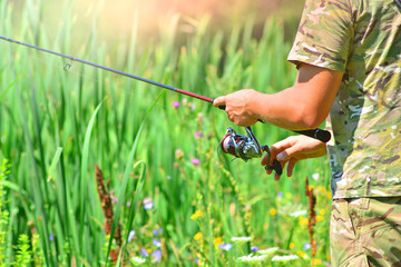 Fishing rod with a coil in a fisherman hands. Pike fishing for spinning.