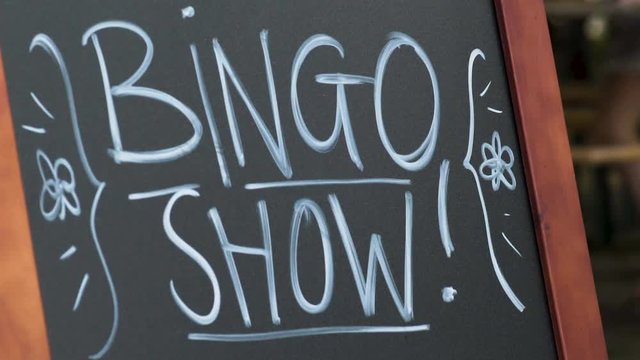 Hand drawn bingo show sign at event with people blurry in the background. Shot on Sony A7SII in 50fps.