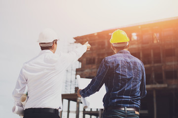 Construction engineers discussion with architects at construction site or building site of highrise...