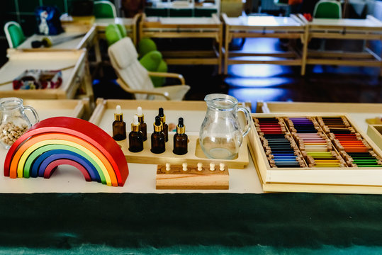 Table and shelving with montessori materíal, colorful rainbow bow in the classroom.