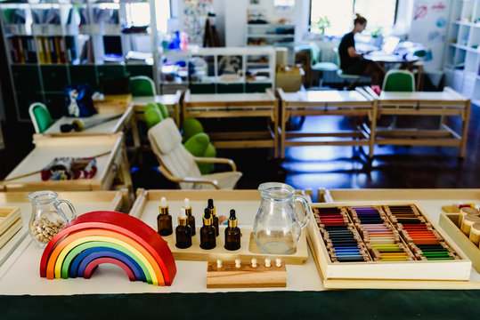 Table and shelving with montessori materíal, colorful rainbow bow in the classroom.