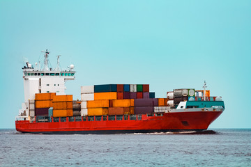 Red container ship underway