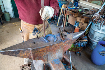 ein Hufeisen wird auf einem Amboss bearbeitet