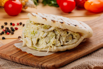 Famous and delicious Venezuelan AREPA called Reina Pepeada on a kitchen board
