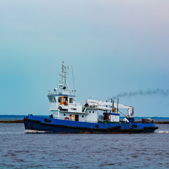Blue tug ship underway