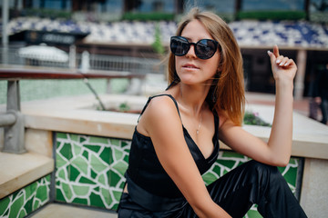 Young pretty woman laughing and sit on the bench outdoors