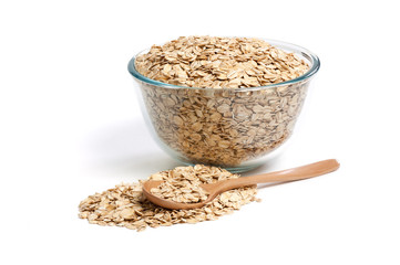 Oat flakes in glass bowl and wooden spoon isolated on white background. High resolution macro close up of oatmeal. Full depth of field stacked image.