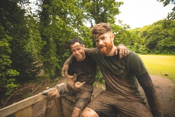 Fit men relaxing over obstacle course