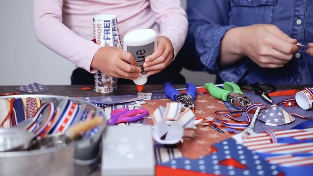 Step by step. Mother and daughter making paper lantern for July 4th celebration