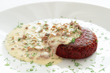 fried beetroot patty with cream and mushrooms sauce sprincled with dill