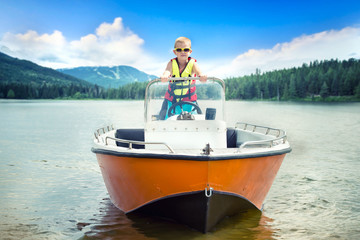 The child dreams of becoming a captain. The first swimming on a motor boat on the lake.