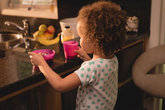 Baby having oats and drink in kitchen
