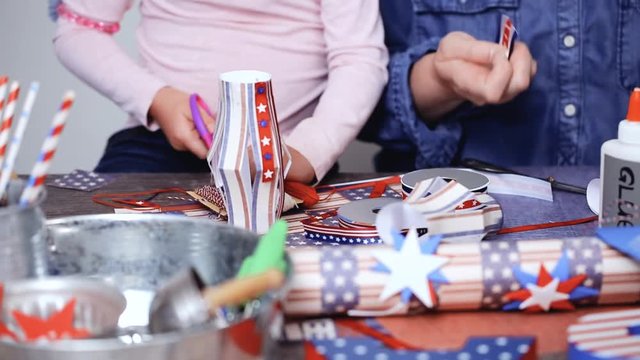 Step by step. Mother and daughter making paper lantern for July 4th celebration