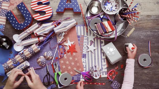 Step by step. Mother and daughter making paper firecrackers for July 4th celebration
